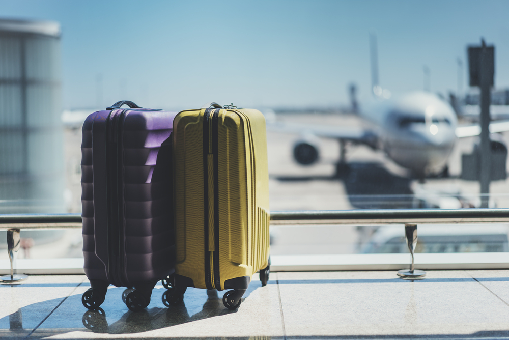 Luggage in an airport with an airplane in the background