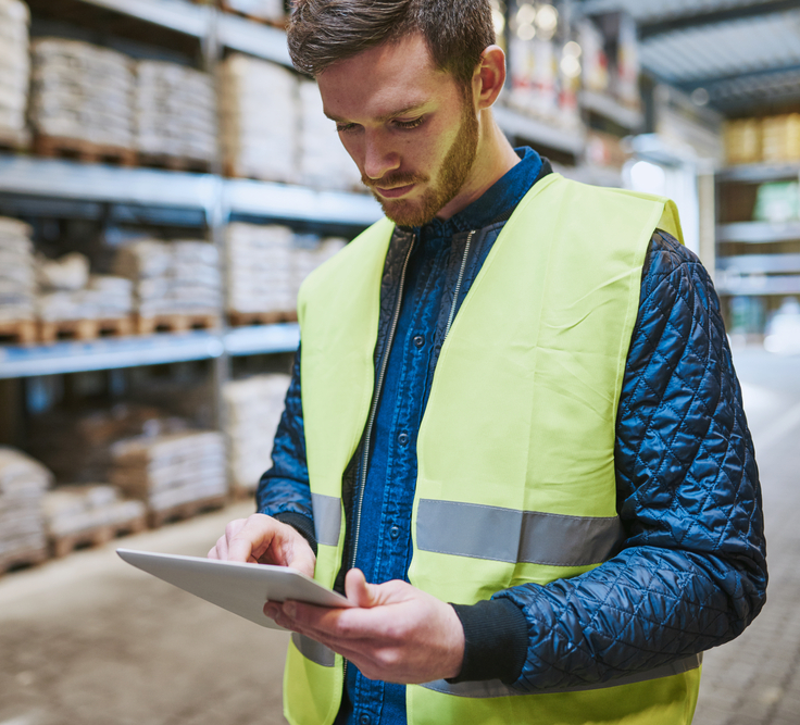 A man in a big warehouse facility full of inventories