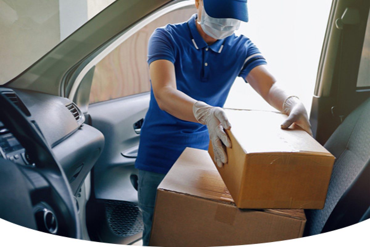 Man wearing mask taking boxes out of car