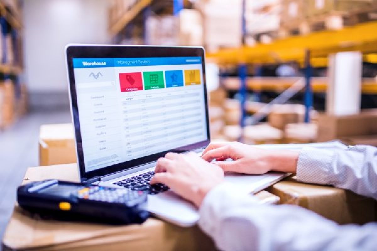 Person working on a laptop on a warehouse