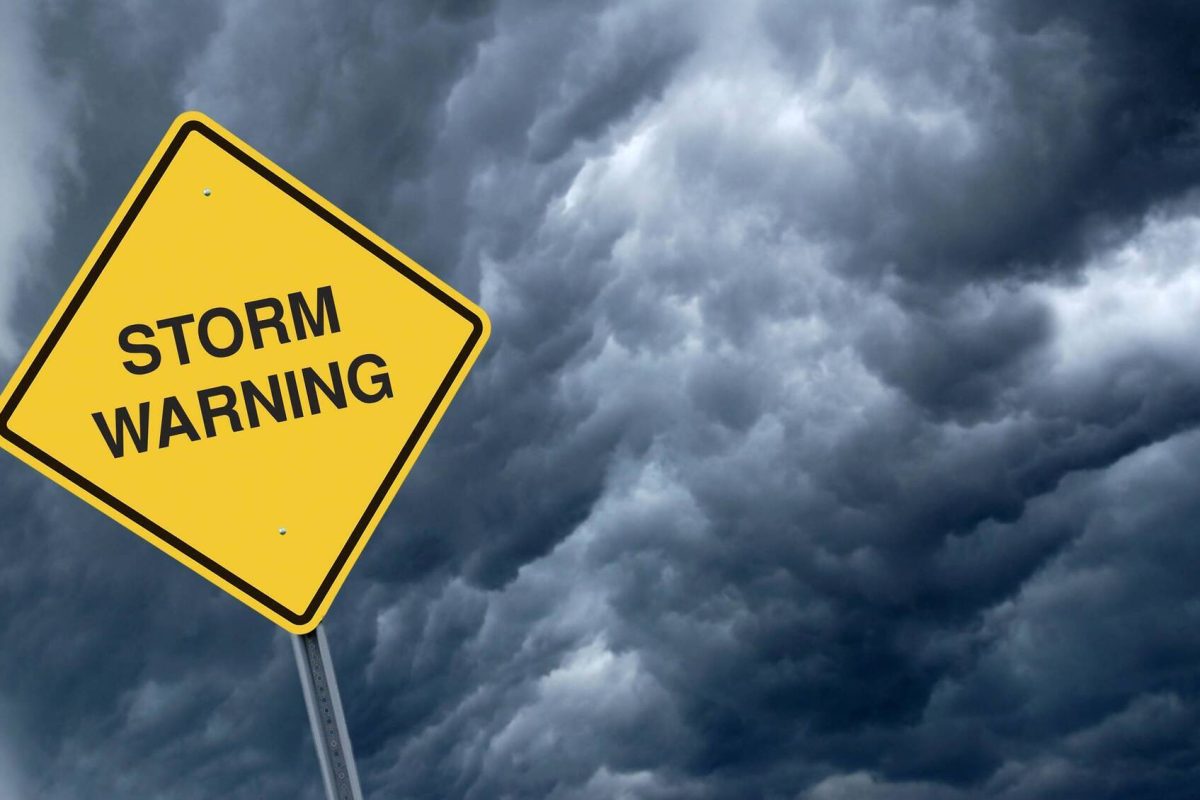 A Caution Sign in Front of dramatic Storm Clouds Warning of Approaching Storms.